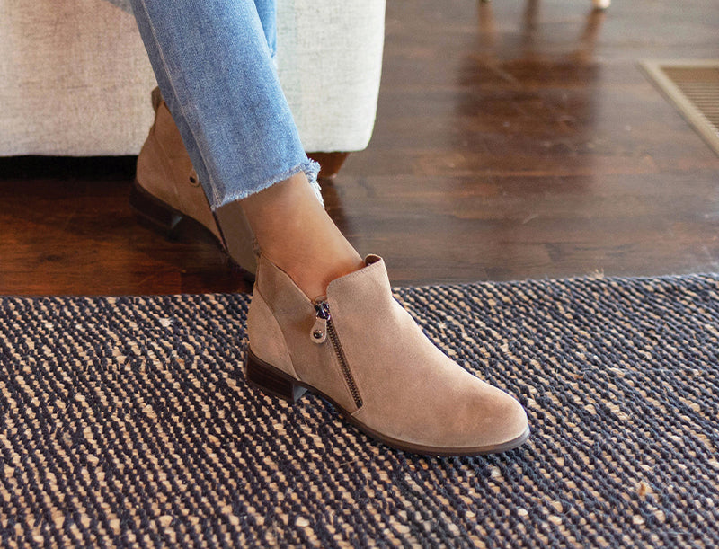 MUNRO NEKO ANKLE BOOTIE IN ALMOND COLOR SUEDE ZIPPERS ON INSIDE AND OUTSIDE  ON MODEL IN BLUE JEANS-CLOSEUP